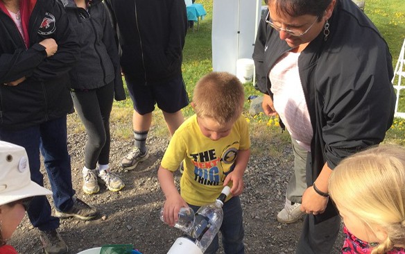 Boy Pours Salmon Down Spout into River