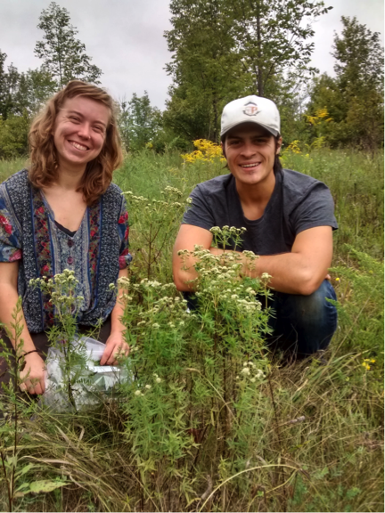 Two Young People Smile in Grasslands at Cedar Haven Farm