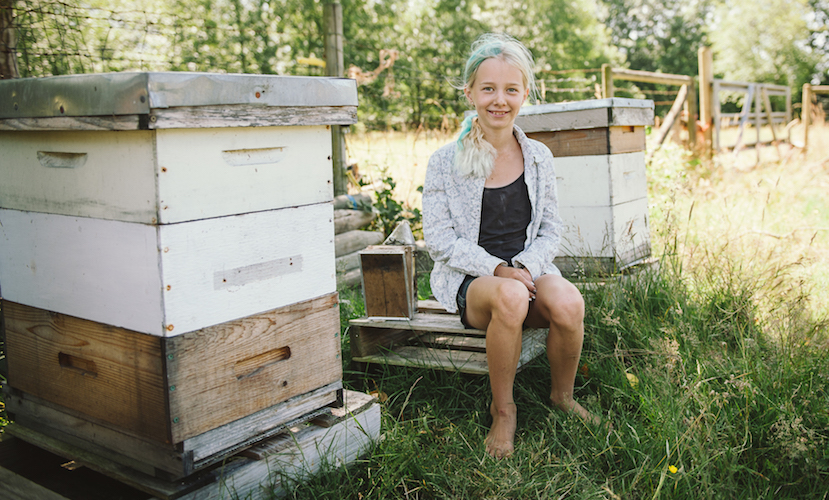 Paul Neufeld's Daugher Poses with Bee Hives
