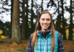 Girl smiling in front of forested area
