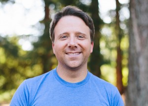 man smiling in front of trees
