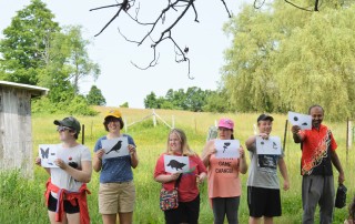 group of people holding papers in front of field