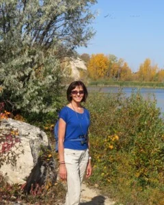Woman, Liz, standing in nature by a lake.