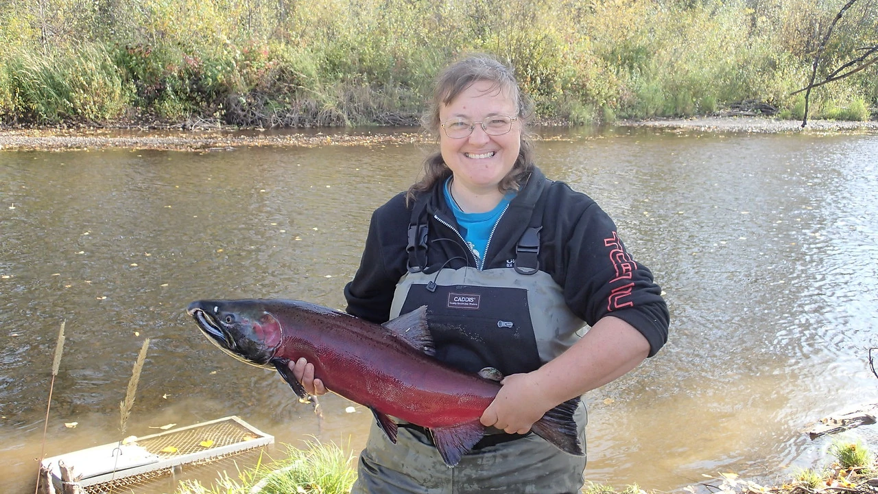 cindy verbeek holding salmon by river