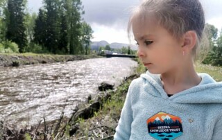 young girl by creek in the spring time