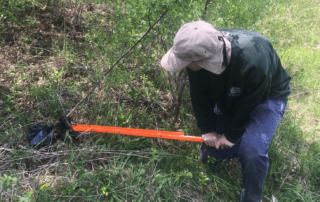 Brent (Summer Staff) using invasive species removal tool at the Cedar Haven Eco-Centre.