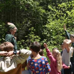 Nature Academy class standing in a semi-circle facing Jacoba. Some students are raising their hands.