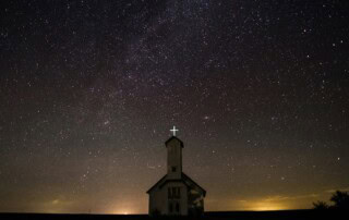 a church in front of a starry night sky