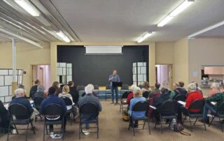 A room full of people listening to a presentation